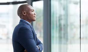 man in business suit staring outside window