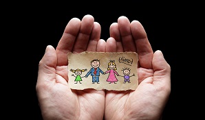 Hands holding paper cut out of family