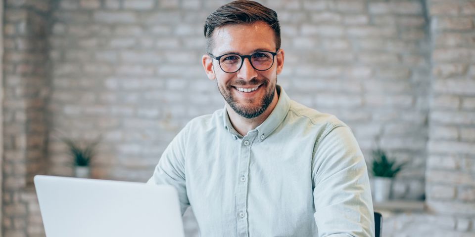 man on laptop smiling