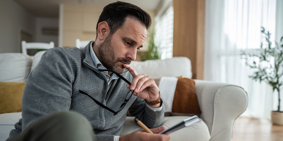 Man looking at phone and thinking