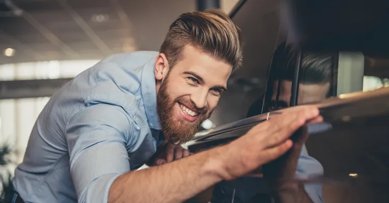 Man standing next to shiny new car